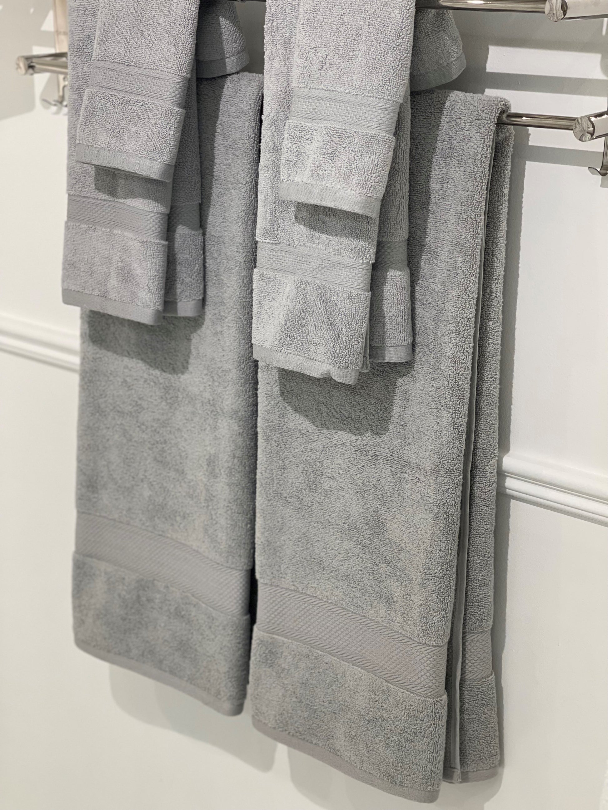 six gray towels hung on a rack