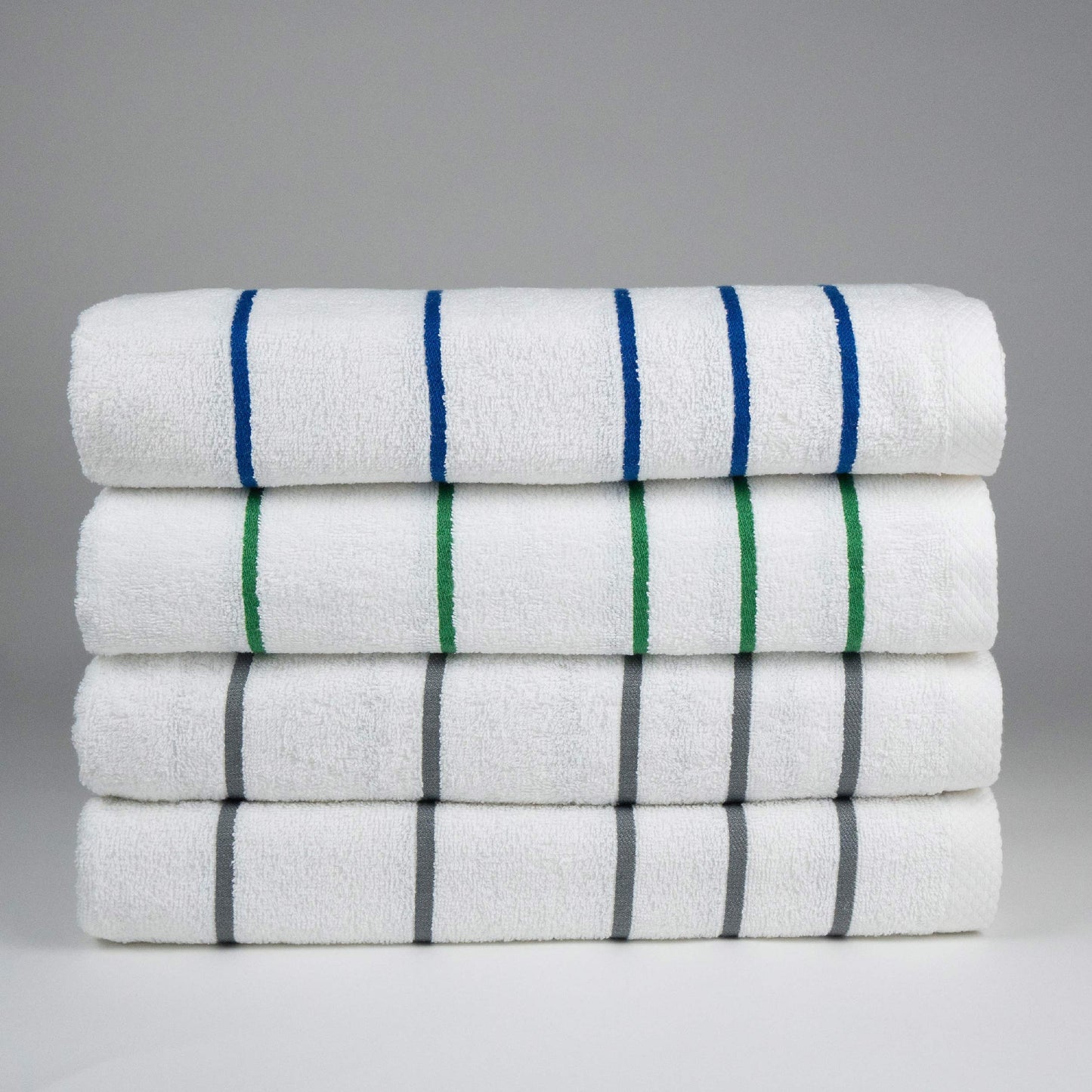 stack of four pool towels, one blue one green two grey