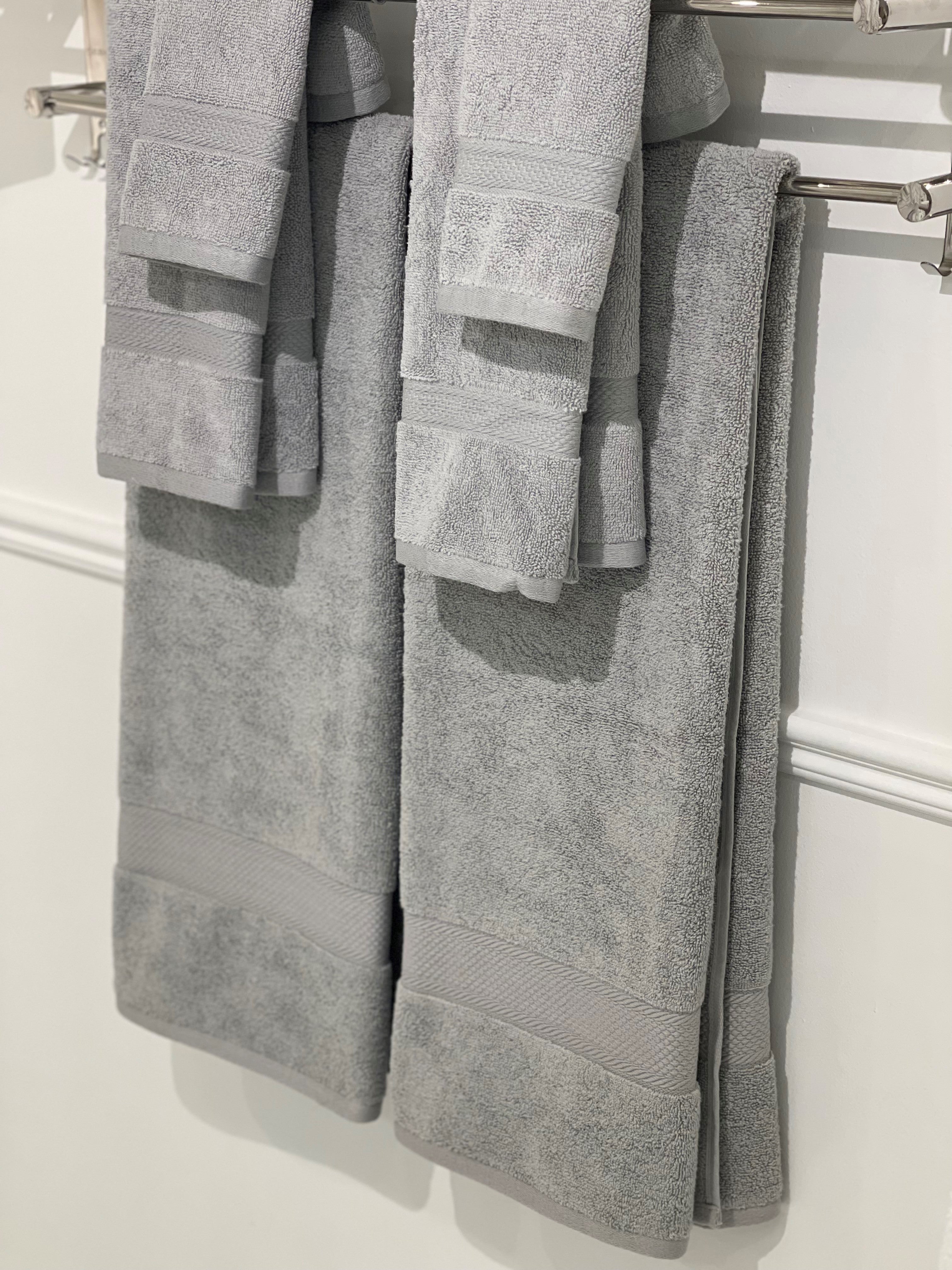 six gray towels hung on a rack