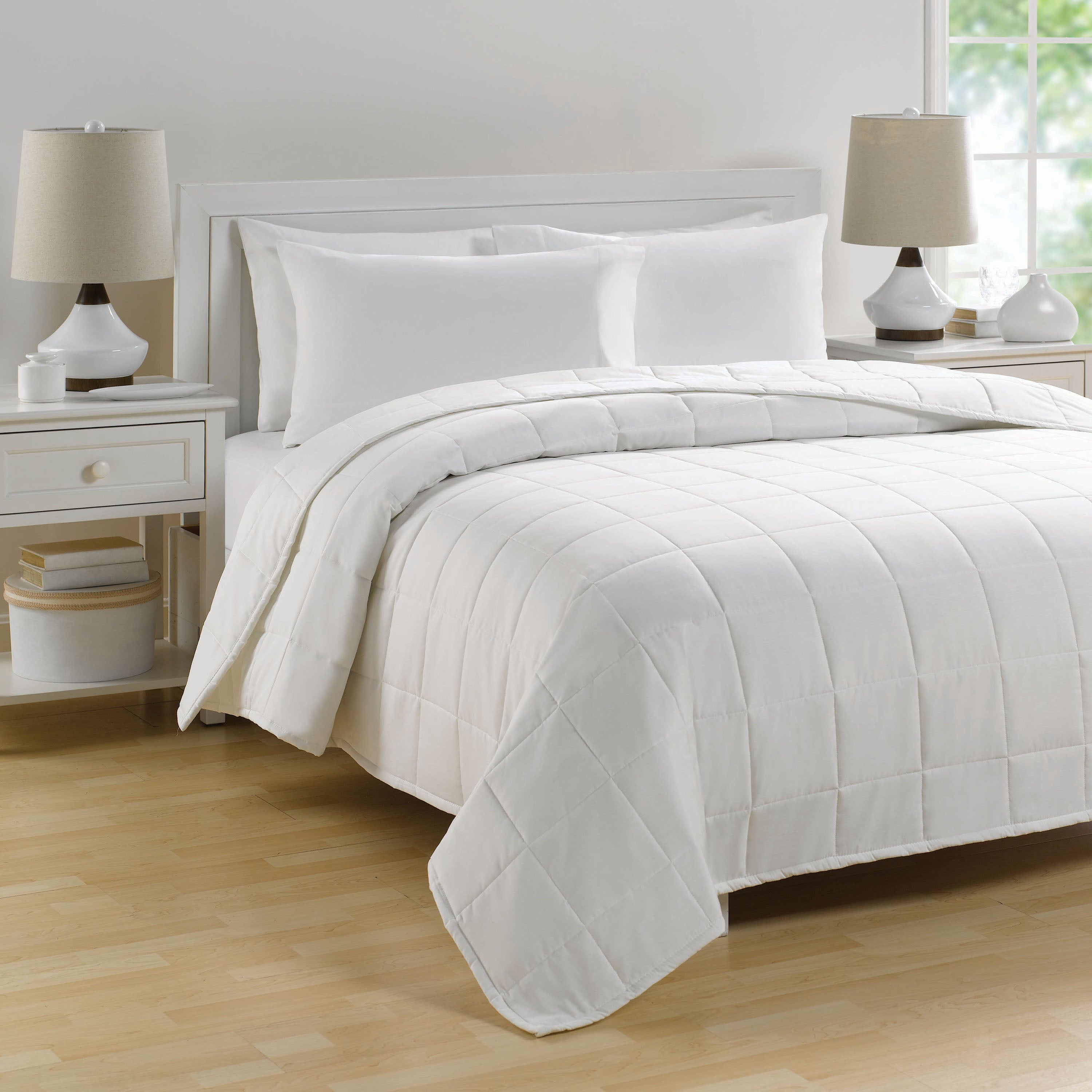 white quilted blanket with down alternative on large bed